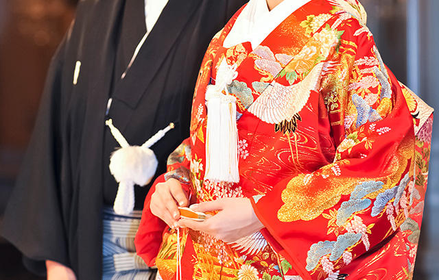 赤い色打掛を着ている新婦と、紋付袴を着ている新郎